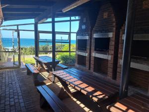 a patio with benches and a view of the ocean at Sun Sea Sand Peacehaven Scottburgh in Scottburgh
