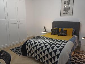 a bedroom with a bed with a black and white comforter at Zaciszny Apartament Old Town Gdansk in Gdańsk