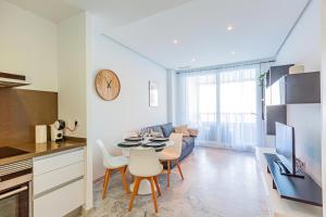 a kitchen and a living room with a table and chairs at GEMELOS sea view apartment in Benidorm