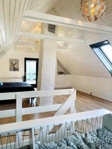 a white room with a bed and a chandelier at Hus på 100 m2 ved skov in Hårlev