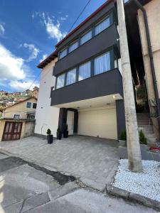 a large white house with a garage at Crystal Apartments Old Town Sarajevo in Sarajevo