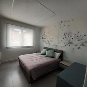 ein Schlafzimmer mit einem Bett mit einem Schneeflocken-Gemälde an der Wand in der Unterkunft Casa Ciliegi 3 in Marostica