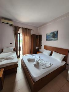 a hotel room with two beds with towels on them at Seashell Beach Rooms in Durrës