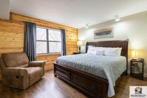 ein Schlafzimmer mit einem Bett, einem Stuhl und einem Fenster in der Unterkunft 3BR Condo with Lake View - Trout Fishing - Playground - 2 Pools - FREE TICKETS INCLUDED - PR69-9 in Branson