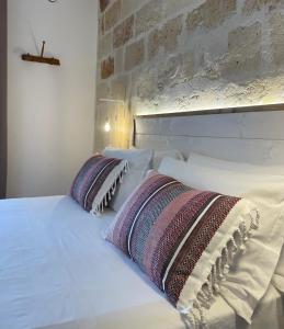 a white bed with two pillows on top of it at Casa Portacrànni in San Pietro in Bevagna