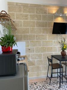 a kitchen with a brick wall and a table and chair at Casa Portacrànni in San Pietro in Bevagna