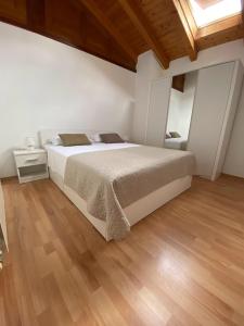a bedroom with a large bed and a wooden floor at Apartman I&I in Peroj