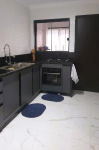 a kitchen with a sink and a stove at Apartamento Excelente Pé na Areia in Guaratuba