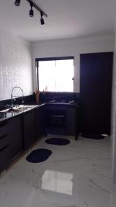 a kitchen with a sink and a large window at Apartamento Excelente Pé na Areia in Guaratuba +16 photos
