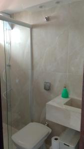 a bathroom with a shower and a toilet and a sink at Apartamento Excelente Pé na Areia in Guaratuba
