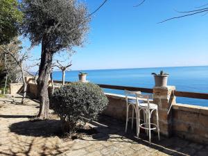 um par de cadeiras sentadas numa parede perto da água em Casa De Santis - Roby e Fra al mare Cavallucci em Isola Capo Rizzuto