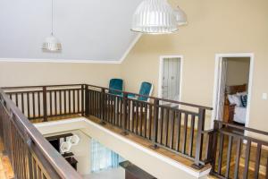 a room with a staircase with two blue chairs at Ocean Breeze Beach House in Port Shepstone