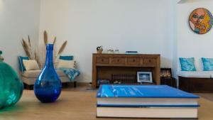 Sala de estar con 2 jarrones azules y mesa en Eco Soul Ericeira Guesthouse - Adults Only, en Ericeira