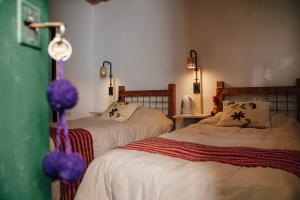 1 dormitorio con 2 camas con sábanas blancas en Casa de la Flia. Sánchez en Humahuaca