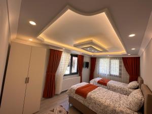 1 dormitorio con 2 camas y techo artesonado en Pocibükensarayları en Çamlıhemşin