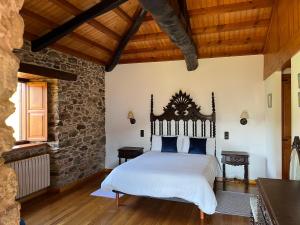 um quarto com uma cama grande e uma cabeceira em madeira em Casa Rural O Vilar em Mera de arriba