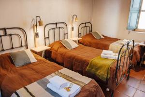a room with three beds with orange sheets at Casa de la Flia. Sánchez in Humahuaca
