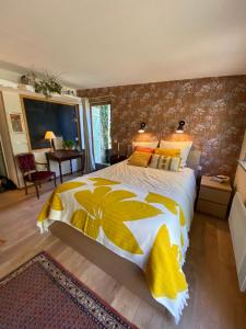 1 dormitorio con 1 cama grande con sábanas blancas y amarillas en Bed and B Les Truffières, en Trémolat
