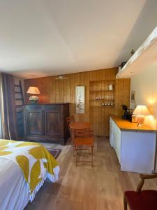 1 dormitorio con cama, mesa y cocina en Bed and B Les Truffières, en Trémolat