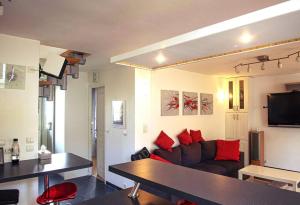 - un salon avec un canapé et des oreillers rouges dans l'établissement Villa Manarola - 10pers/4Ch - jacuzzi & jardin, à Longjumeau