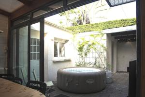 a large tub sitting in the middle of a patio at Villa Manarola - 10pers/4Ch - jacuzzi & jardin in Longjumeau