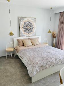 a bedroom with a large bed and two chairs at Vixen Apartment Studio 2 in Theologos