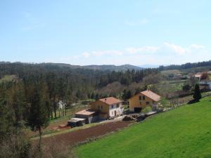 dom na wzgórzu z górami w tle w obiekcie Pensión Residencial Platas w mieście O Pedrouzo