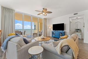 a living room with a couch and a tv and a living room at Beach Colony East 17B-Penthouse in Perdido Key