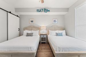 two beds in a bedroom with white walls at Beach Colony East 17B-Penthouse in Perdido Key +57 photos