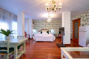 1 dormitorio con cama, mesa y TV en Apartamentos Chvictoria, en Cuenca