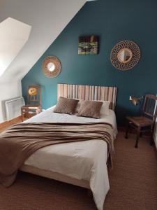 1 dormitorio con 1 cama grande y pared azul en Le Relais des Fontaines, en Nouans-les-Fontaines