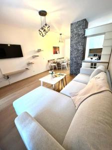 ein Wohnzimmer mit einem Sofa und einem TV in der Unterkunft Апартамент Ренета Apartment Reneta in Welingrad
