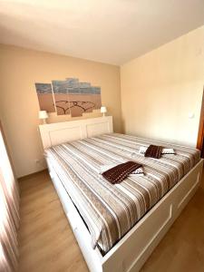 Schlafzimmer mit einem Bett mit gestreifter Decke in der Unterkunft Апартамент Ренета Apartment Reneta in Welingrad