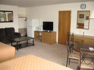 綠河的住宿－Little Bear Motel，带沙发和桌子的客厅以及厨房。