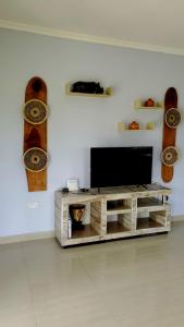 a flat screen tv sitting on top of a wooden entertainment center at Sweet Retreat-1 in Lusaka