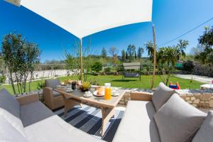 a patio with a table and chairs with a view of a yard at Giannakis Villa in Kanakádes