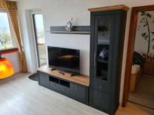 a living room with a entertainment center with a flat screen tv at Heiligenhafen Ostseeblick Aquamarina 57 in Heiligenhafen