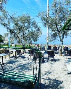 um parque com cadeiras e mesas e árvores e um baloiço em De La Terrasse IZNIK em İznik