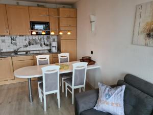 a kitchen with a table and chairs and a couch at Heiligenhafen Ostseeblick Aquamarina 57 in Heiligenhafen