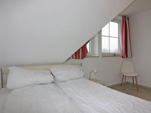 a bedroom with a bed with white sheets and a window at Ferienwohnung Seemöwe im Fährhaus in Vieregge in Vieregge