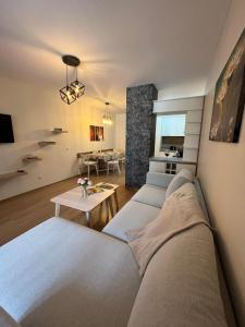 ein Wohnzimmer mit einem Sofa und einem Tisch in der Unterkunft Апартамент Ренета Apartment Reneta in Welingrad