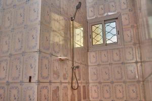 łazienka z prysznicem i oknem w obiekcie Face Nal w mieście Duala