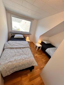 - une chambre mansardée avec 2 lits et une fenêtre dans l'établissement HBA Appartsments, à Malmö
