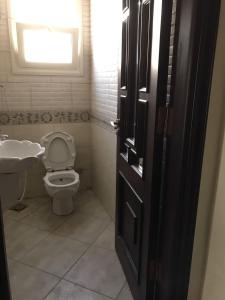 bagno con servizi igienici, lavandino e finestra di Royal Palace apartment 5 Stars a Il Cairo