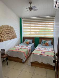 2 Betten in einem Zimmer mit Fenster in der Unterkunft Casa 1090 ubicada cerca a todo. in Leticia