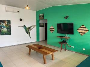 una sala de estar con una pared verde con un pájaro en la pared en Casa 1090 ubicada cerca a todo., en Leticia