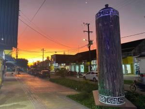 un poteau sur le côté d'une rue au coucher du soleil dans l'établissement Casa 1090 ubicada cerca a todo., à Leticia