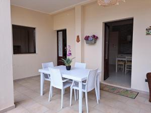 a white dining room table with white chairs at I Sogni di Alice in Pula