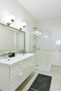 a white bathroom with a sink and a mirror at Villa Garden in Eger