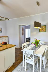 uma cozinha e sala de jantar com uma mesa branca e cadeiras em Villa Garden em Eger